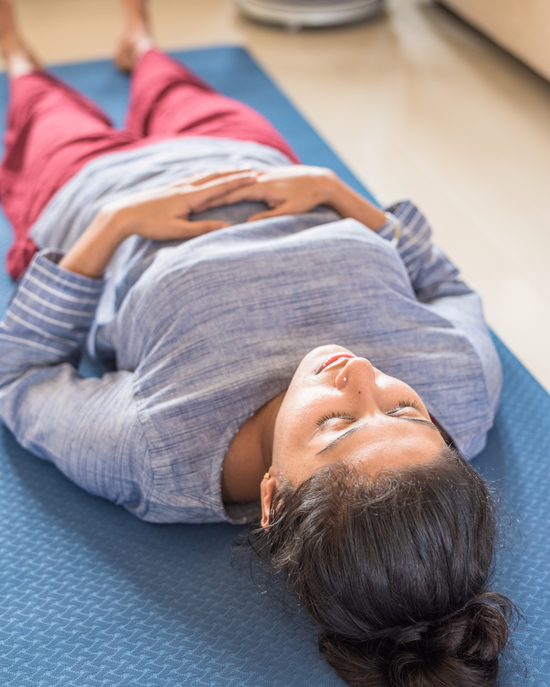 Relaxed and ready to engage in a breathwork or yoga session, woman lying on the floor with closed eyes