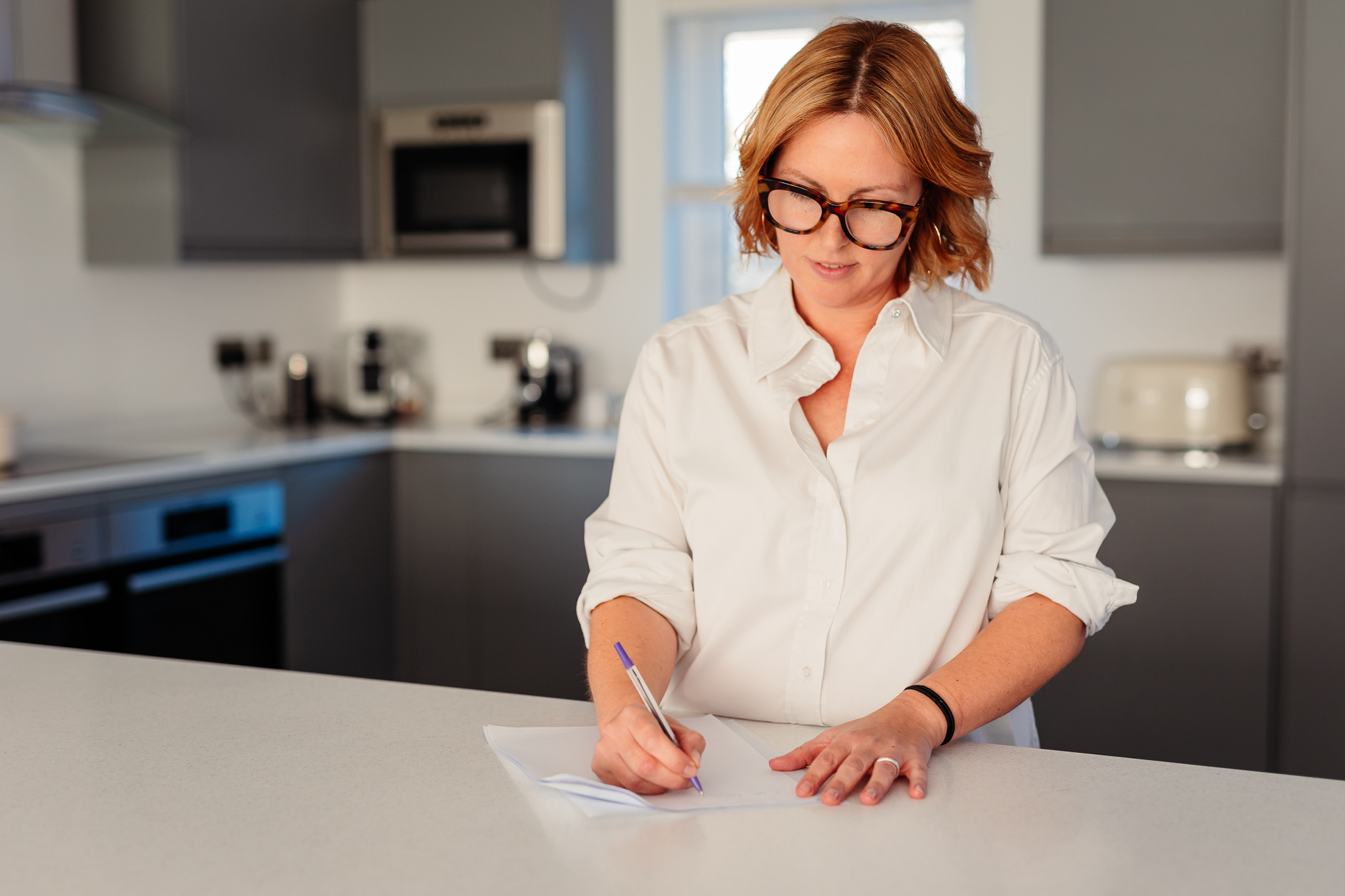 Essex Menopause Coach in a kitchen writing a meal plan